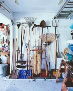 garage with rakes, shovels, sled, and tools