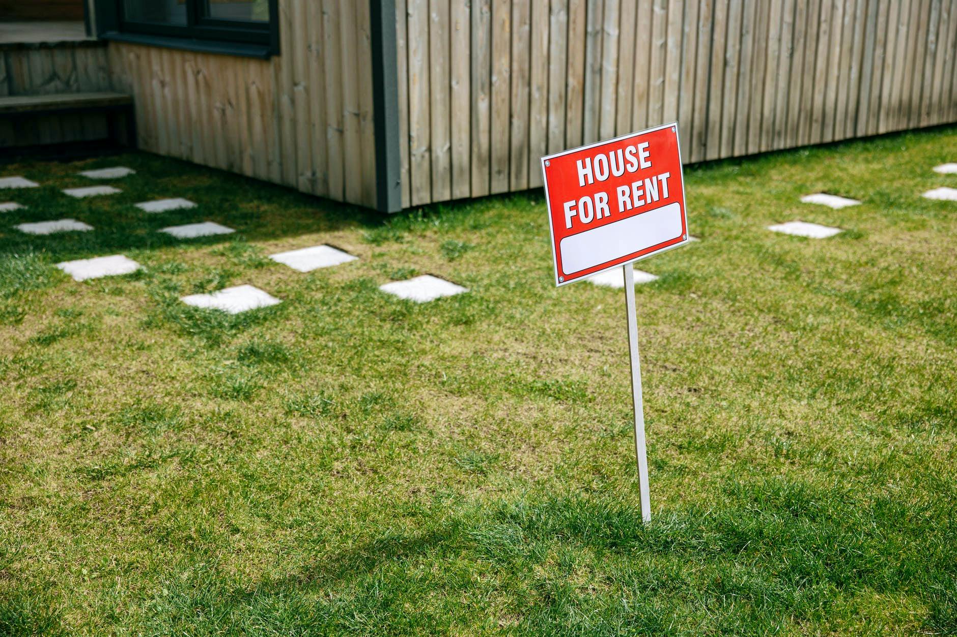red and white sign board on the lawn grass